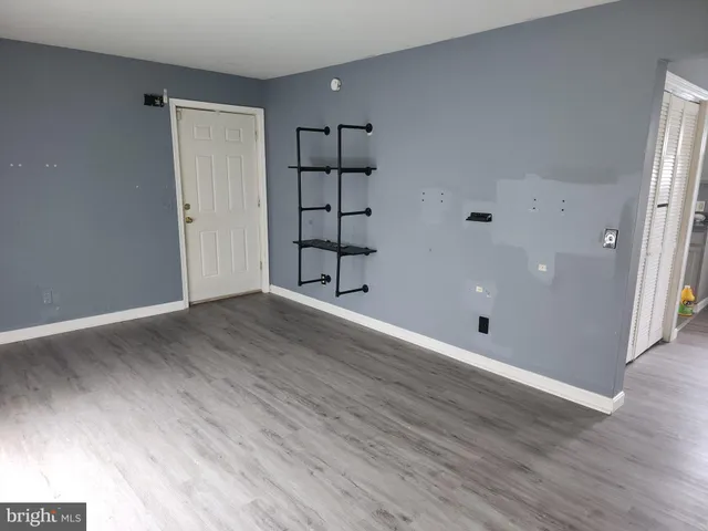an empty room with wooden floor and cabinet