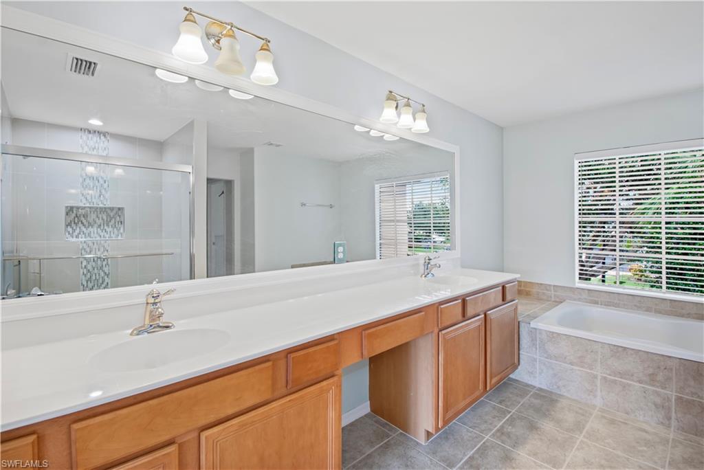 2133 Fairmont Lane Naples, FL 34120 - Photo 11 of 31 a spacious bathroom with a granite countertop sink a large mirror and a bathtub