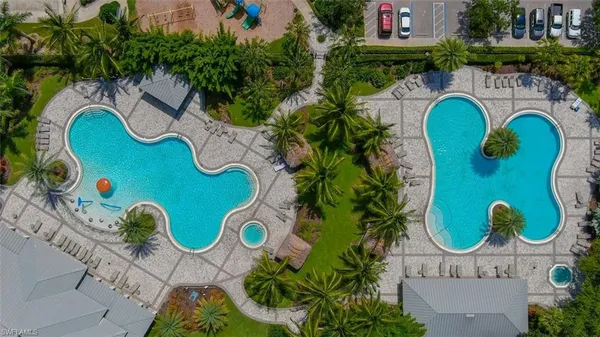 an aerial view of a swimming pool with outdoor seating and yard