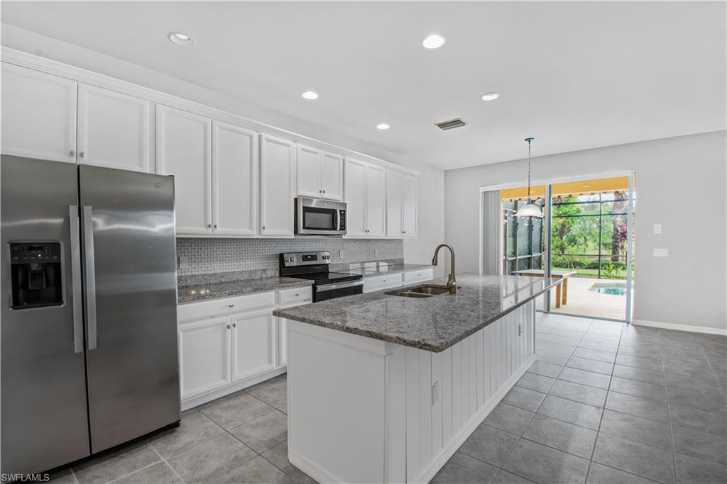 2133 Fairmont Lane Naples, FL 34120 - Photo 6 of 31 a kitchen with stainless steel appliances granite countertop a sink stove and refrigerator