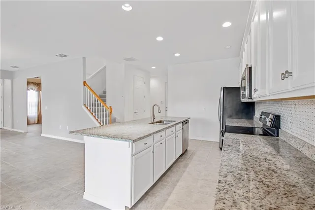 a large white kitchen with a sink and dishwasher