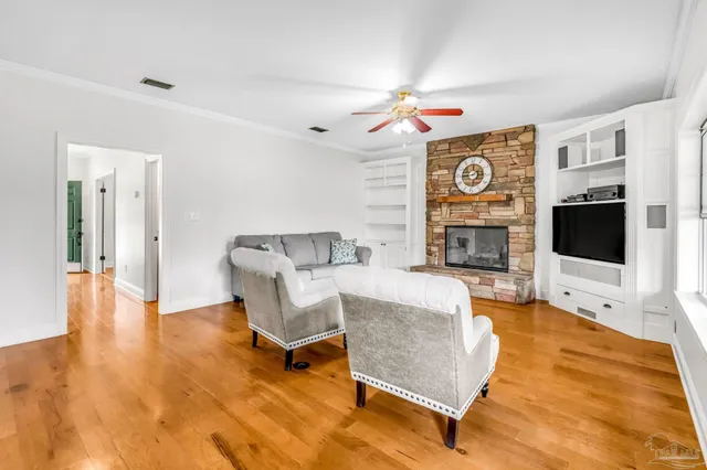a view of empty room with wooden floor and fan