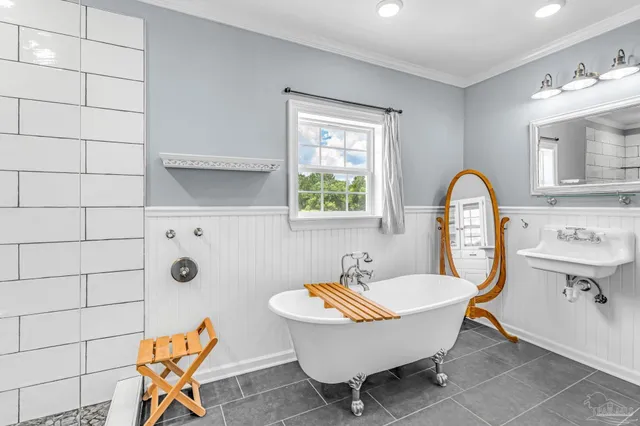 a white bath tub sitting in a bathroom next to a window