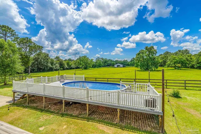 a view of a backyard with swimming pool