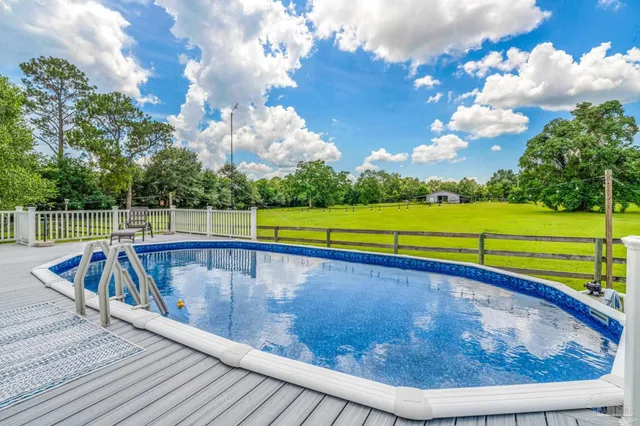 a view of a house with a yard patio and swimming pool