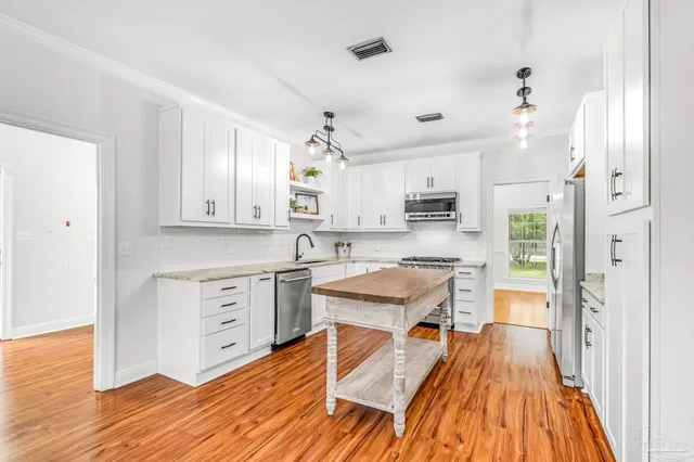a kitchen with white cabinets and stainless steel appliances