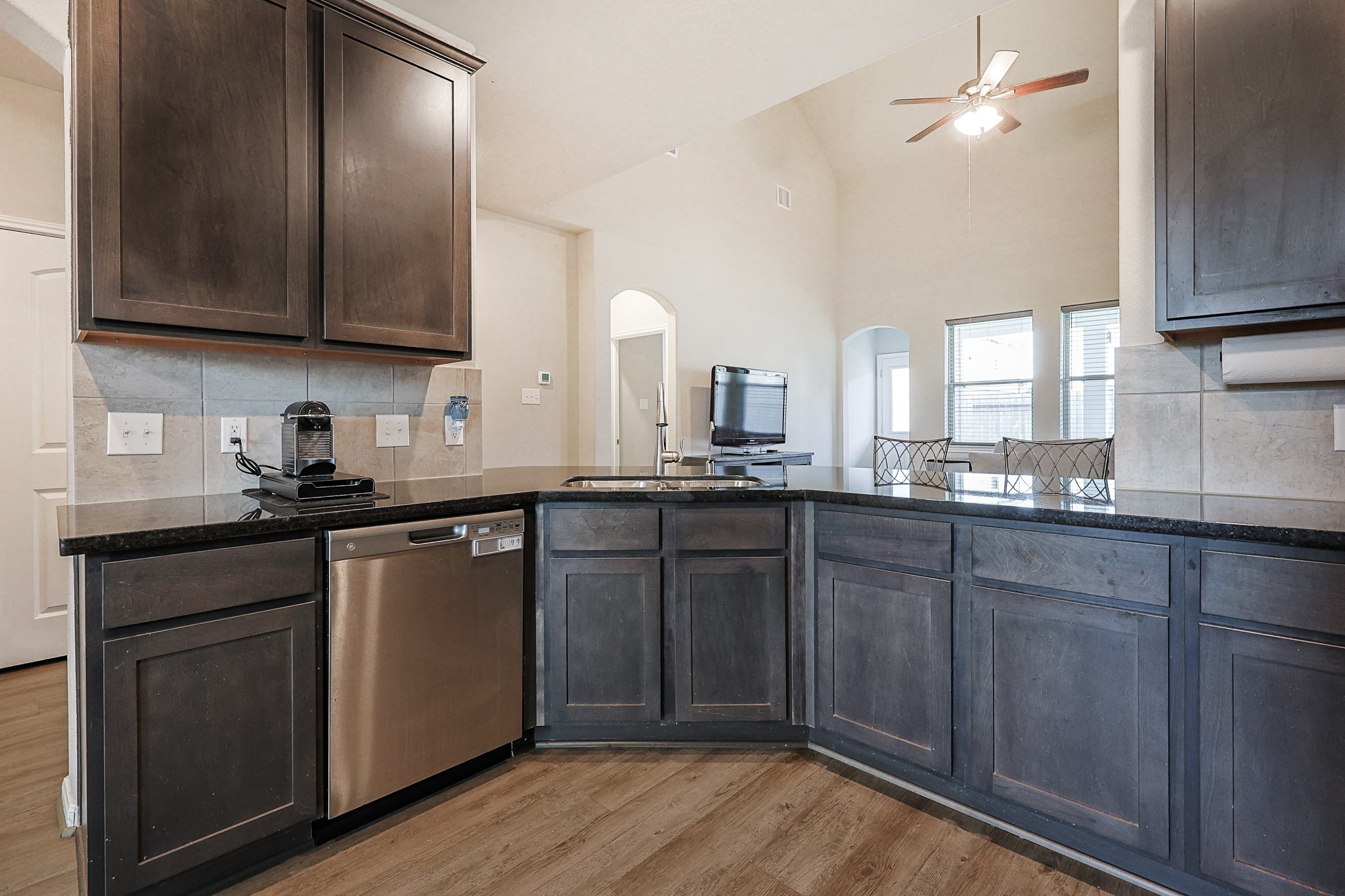 10423 Rochester Hls Lane Tomball, TX 77375 - Photo 13 of 36 Rich, dark cabinetry lines the walls, offering an abundance of storage space that pairs elegantly with the sleek, dark polished countertops.