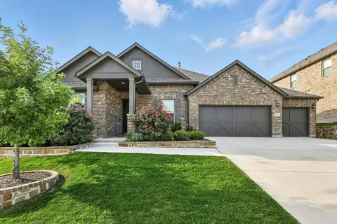 a front view of a house with a garden and yard