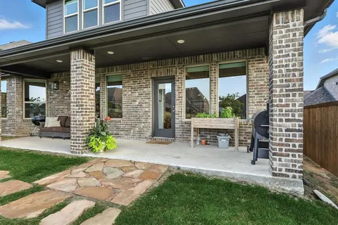 a view of a chair and table in backyard of the house