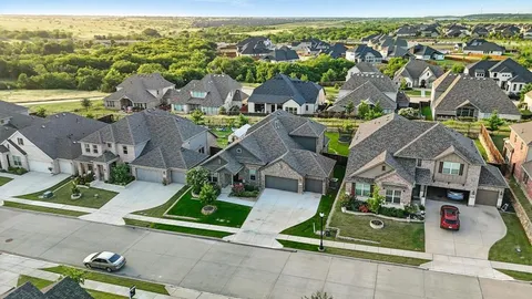 an aerial view of residential houses with outdoor space and ocean view