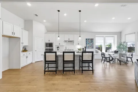a kitchen with kitchen island granite countertop a table and chairs in it