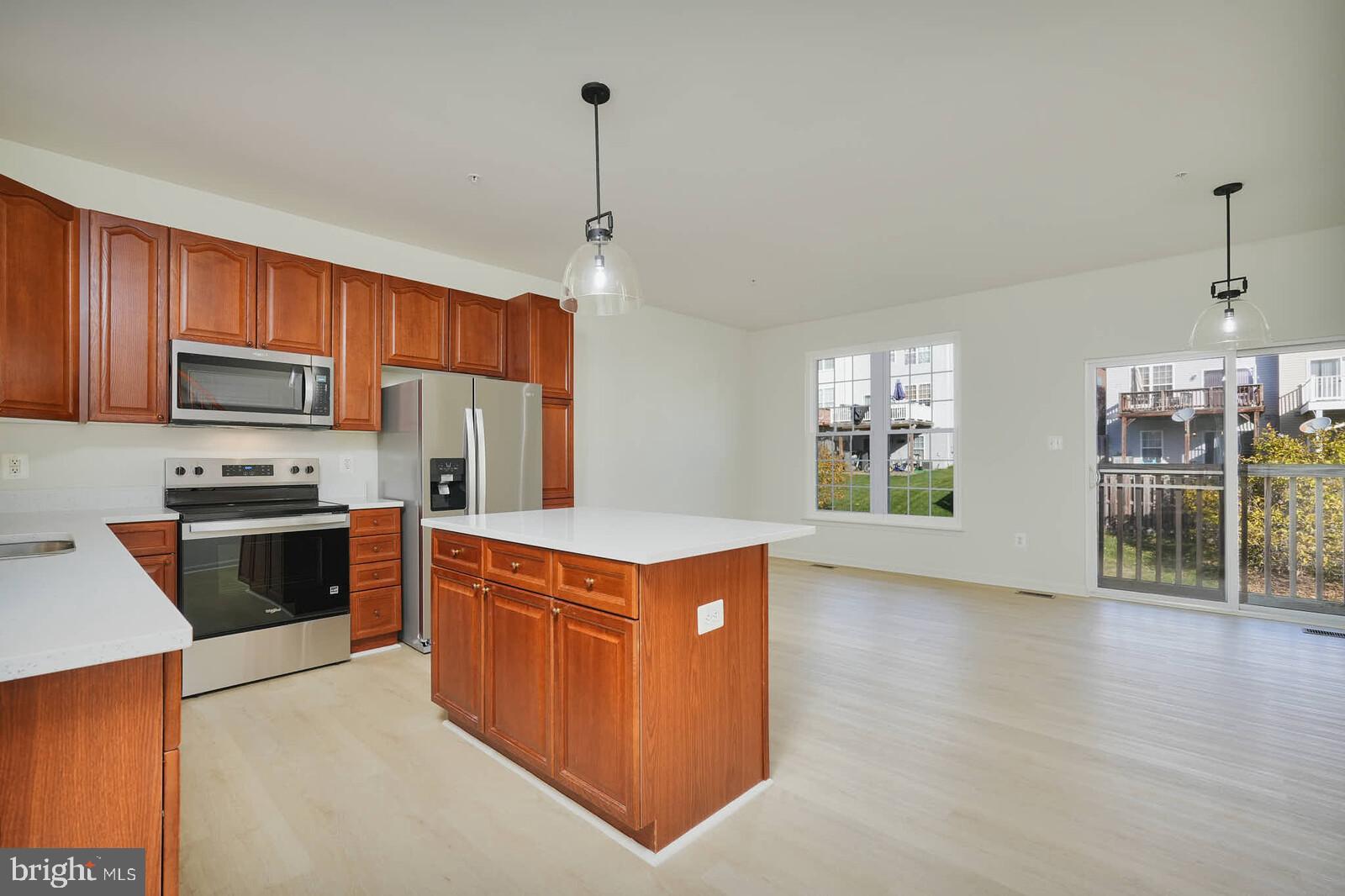 3506 Connor Place Frederick, MD 21704 - Photo 8 of 34 a kitchen with stainless steel appliances granite countertop a stove top oven a sink dishwasher a refrigerator and a dining table with wooden floor