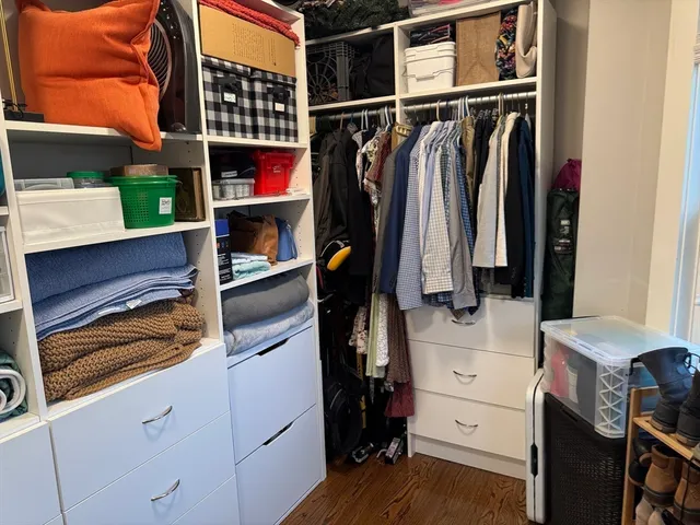 a view of walk in closet with clothes and shoes