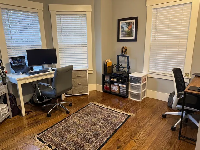 a view of a workspace with furniture and a window