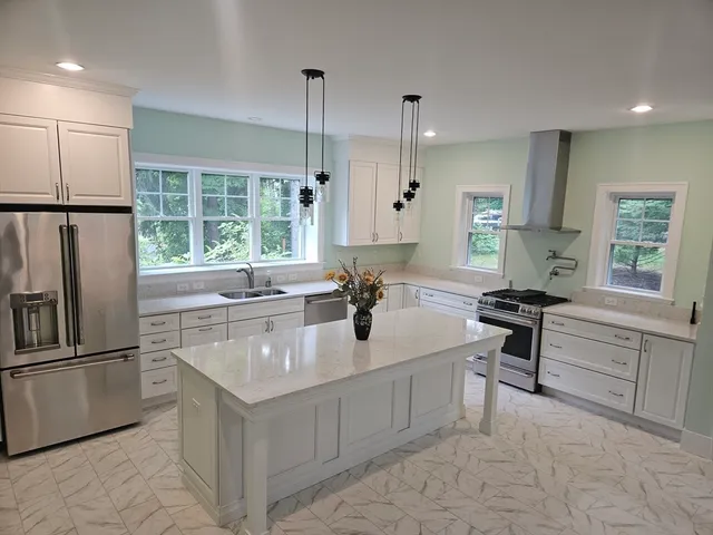 a kitchen with stainless steel appliances granite countertop a sink stove and refrigerator