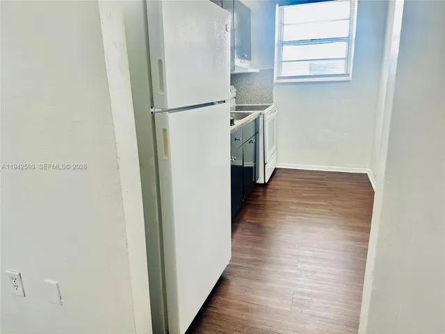 a view of a kitchen with a refrigerator and window