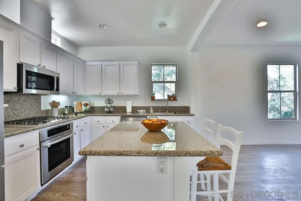2297 Huntington Point Road, Unit 162 Chula Vista, CA 91914 - Photo 14 of 59 a kitchen with granite countertop stainless steel appliances a stove a sink and a microwave