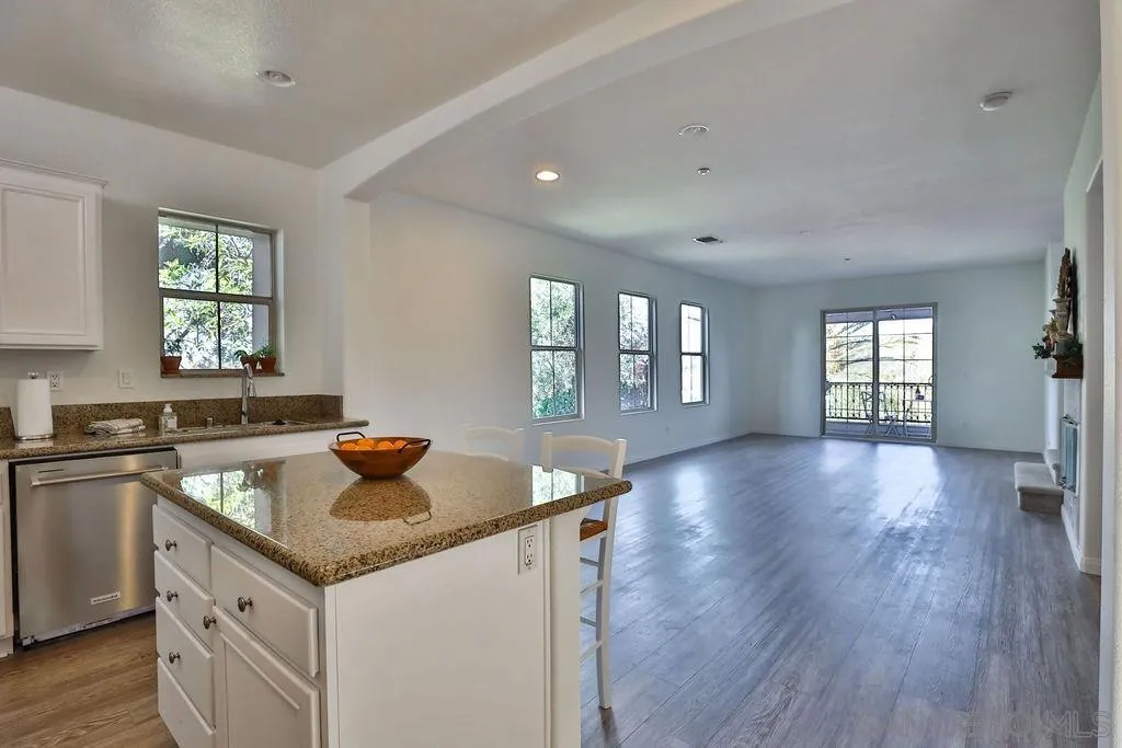 2297 Huntington Point Road, Unit 162 Chula Vista, CA 91914 - Photo 17 of 59 a kitchen that has a sink a microwave oven a dining table and chairs in it