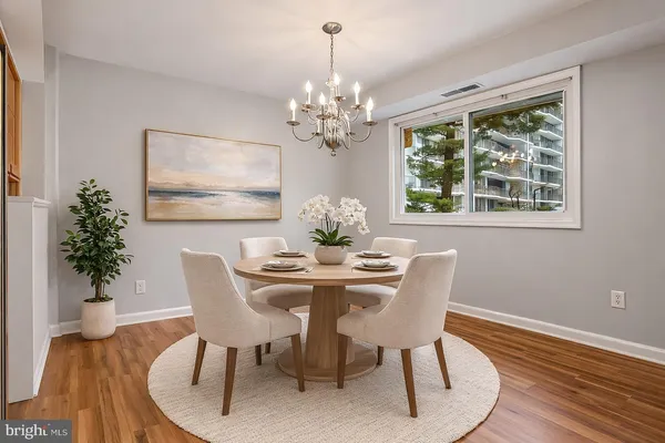 a dining room with furniture a large window and wooden floor