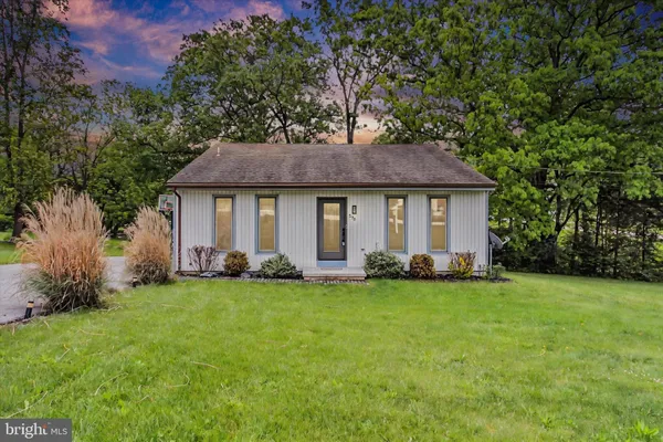 a front view of a house with a garden and yard