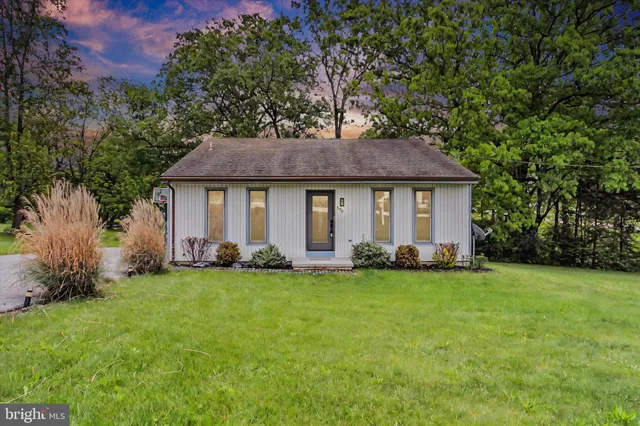 a front view of a house with a garden and yard