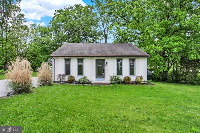 a front view of a house with a garden and yard