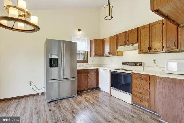 a kitchen with granite countertop wooden floors and stainless steel appliances