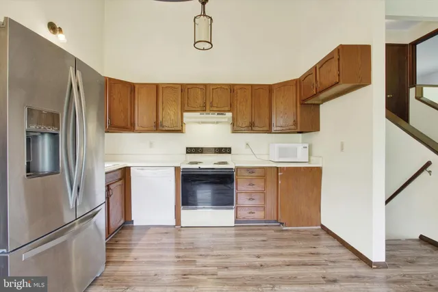 a kitchen with granite countertop a refrigerator stove and sink