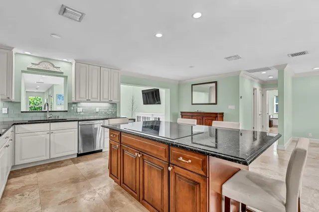 a kitchen with stainless steel appliances granite countertop sink stove refrigerator and cabinets