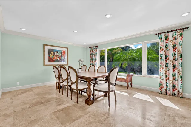 a dining room with furniture and a floor to ceiling window