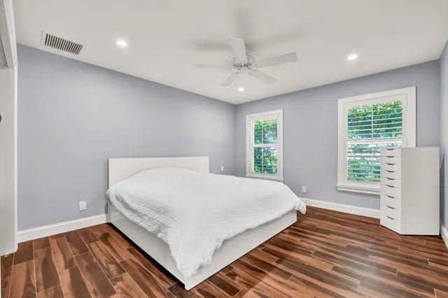 a bed sitting in a spacious bedroom next to a window