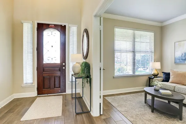 a hall with kitchen island white cabinets and wooden floor