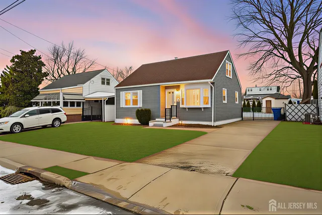 a front view of a house with a garden and trees