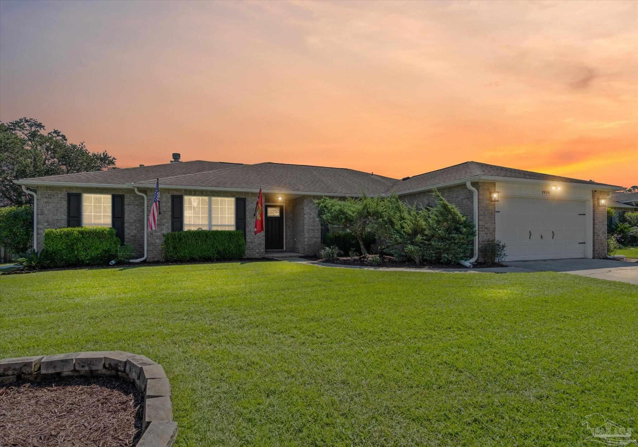a front view of a house with a garden and yard