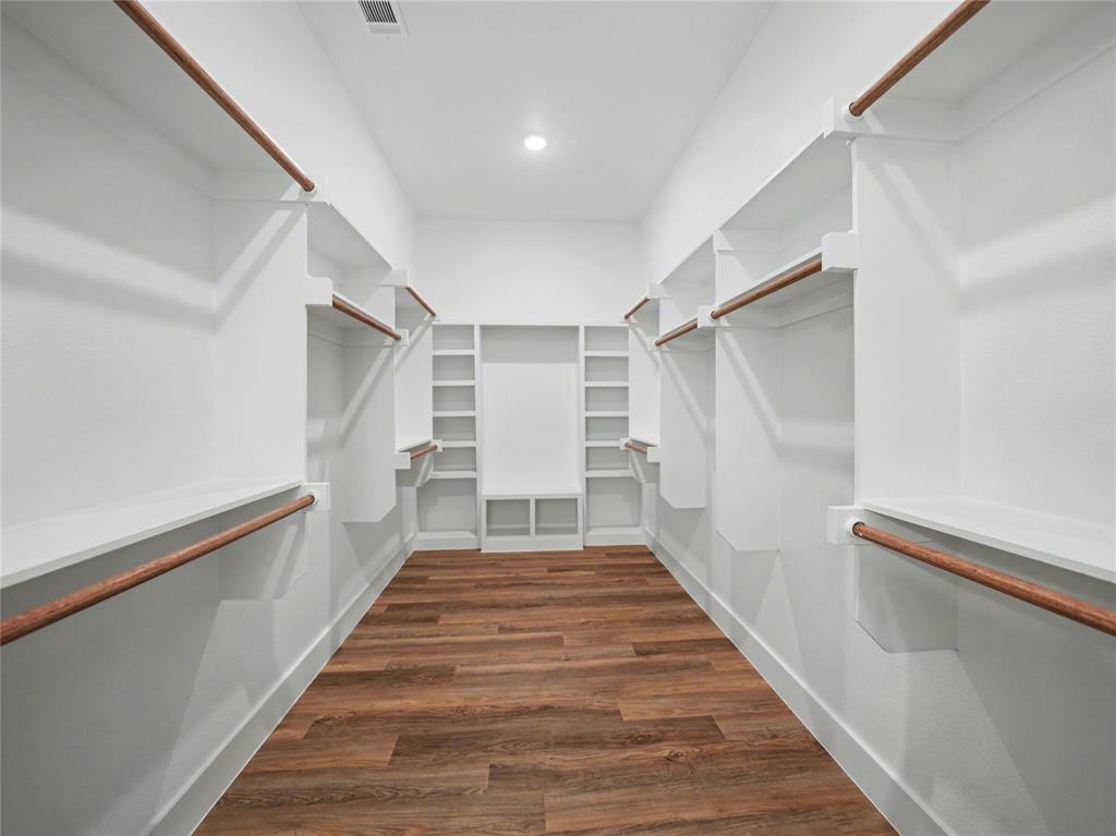 328 Slimp Bluff Azle, TX 76020 - Photo 21 of 30 Spacious walk-in closet featuring wood-finish flooring, extensive built-in shelving, multiple hanging rods, and recessed lighting