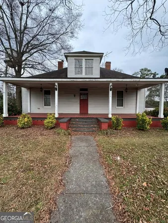 a front view of house with yard and trees in the background