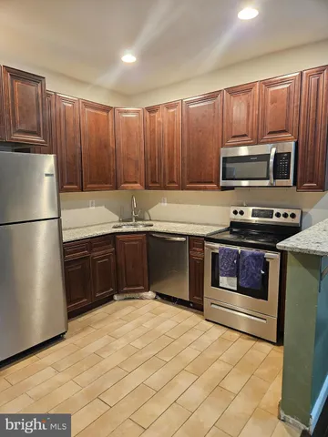 a kitchen with kitchen island granite countertop stainless steel appliances and cabinets