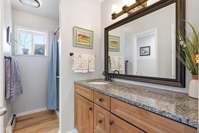 a bathroom with a granite countertop sink and a mirror
