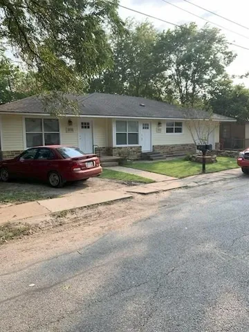 a front view of a house with a garden and plants