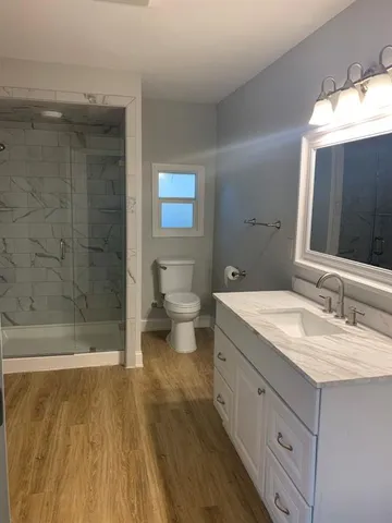 a bathroom with a granite countertop sink toilet and shower