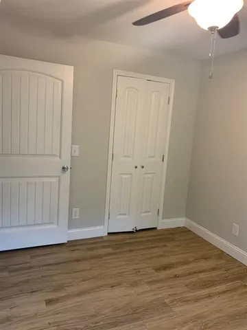 a view of an empty room with wooden floor