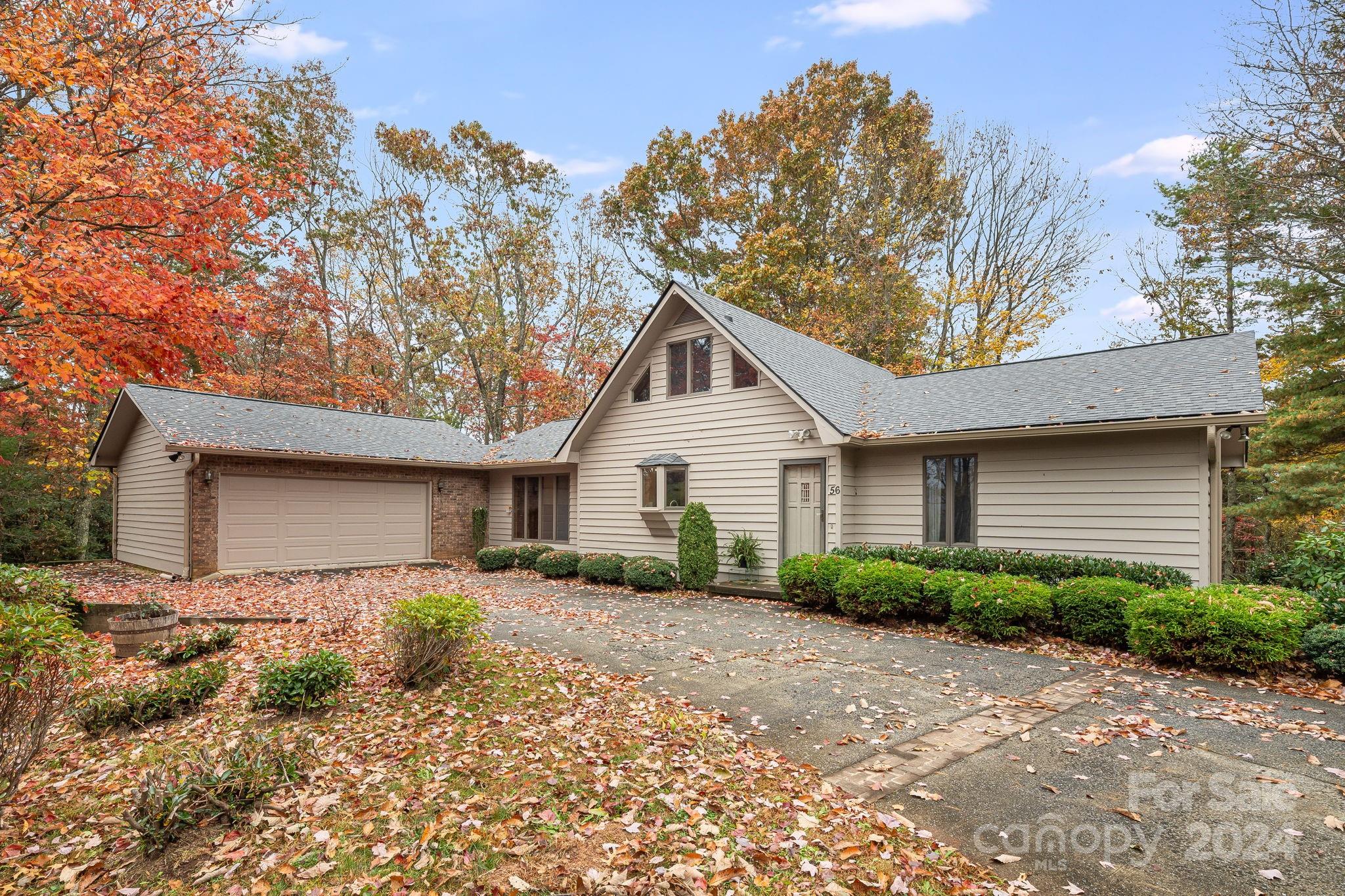 56 Whitaker View Road Fairview, NC 28730 - Photo 1 of 34 a front view of a house with a yard and garage