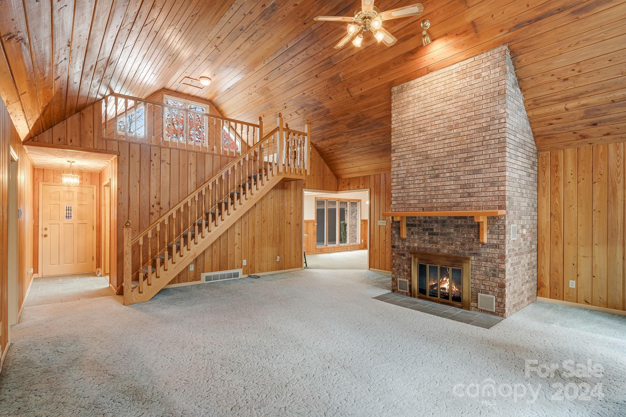 56 Whitaker View Road Fairview, NC 28730 - Photo 6 of 34 a view of an empty room with stairs and a fireplace