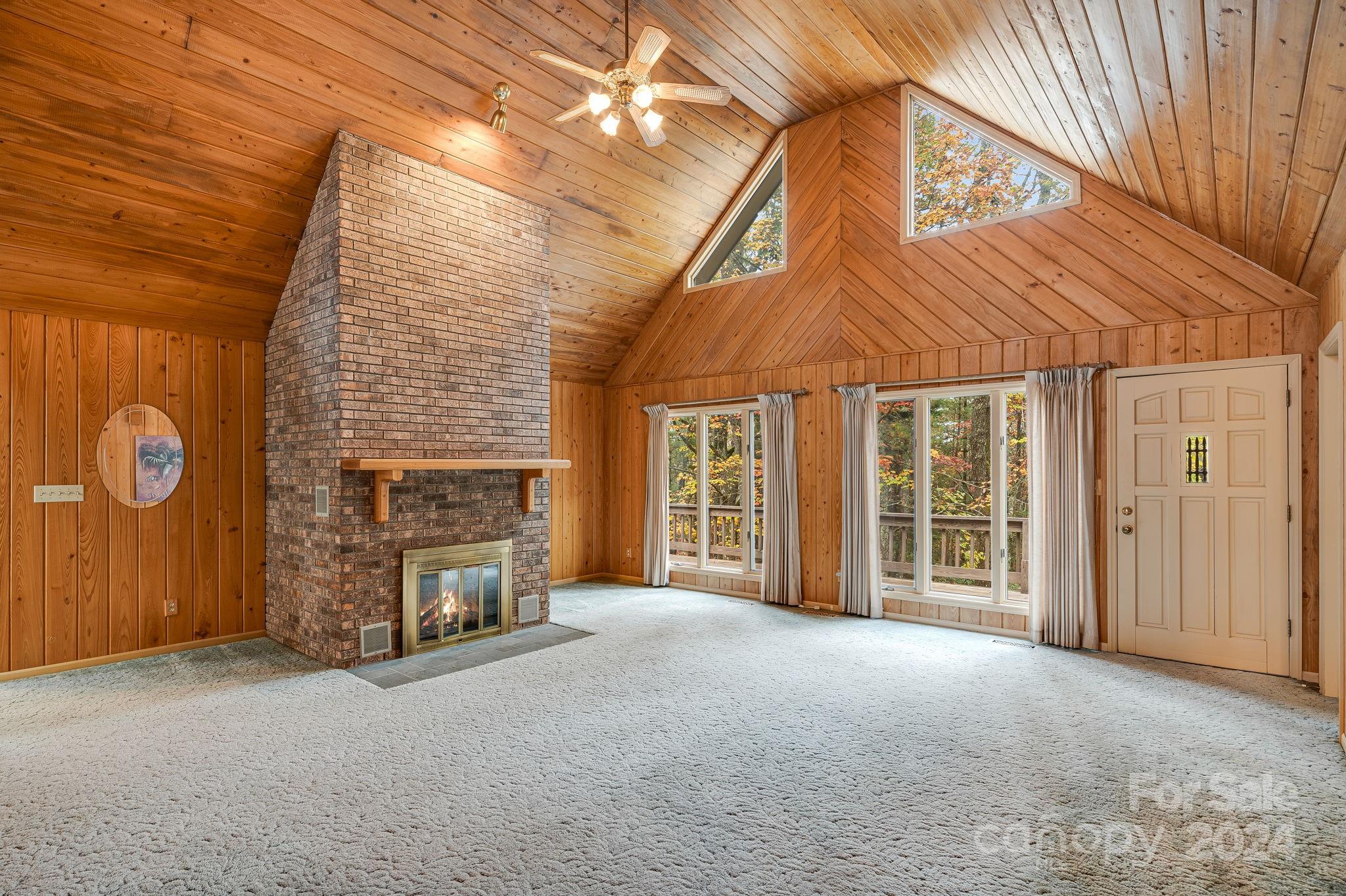 56 Whitaker View Road Fairview, NC 28730 - Photo 8 of 34 an empty room with windows fireplace and fan