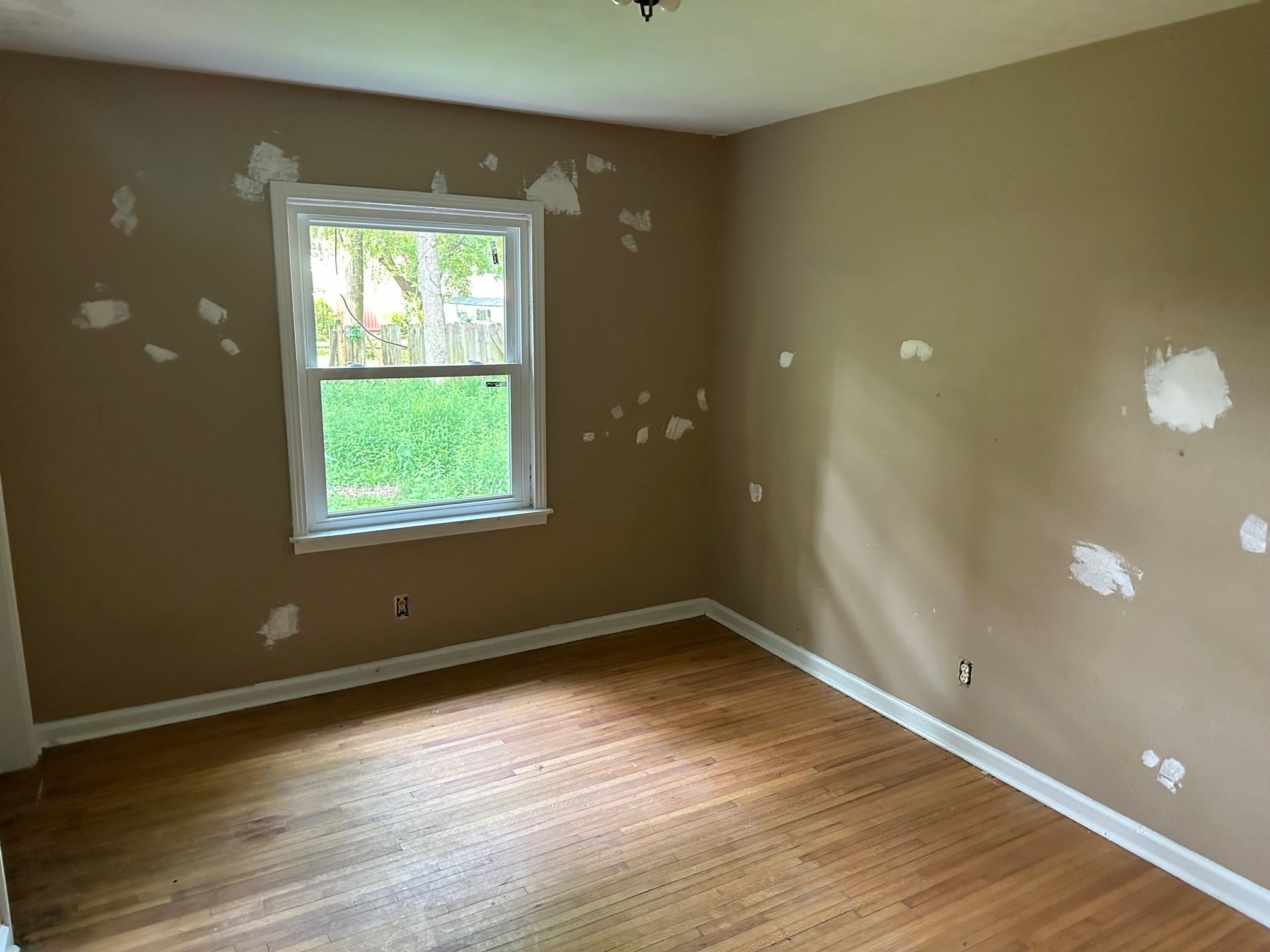 4483 Yale Road Memphis, TN 38128 - Photo 6 of 10 an empty room with wooden floor and windows