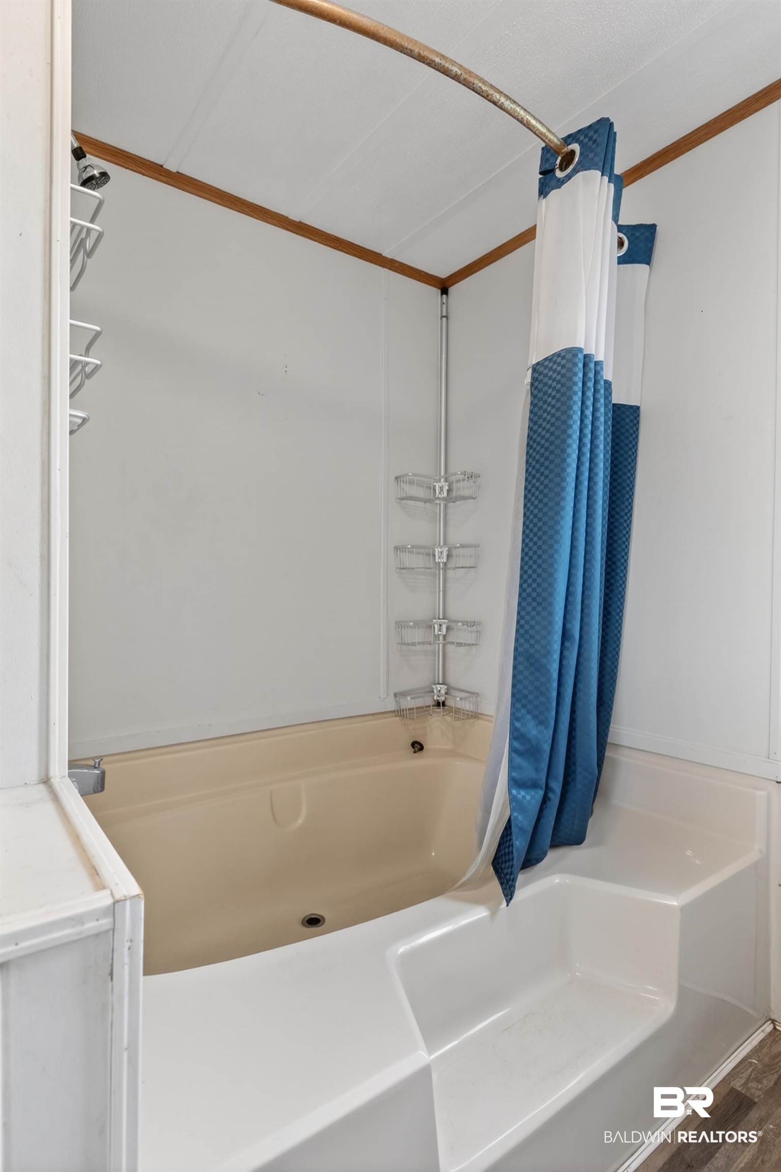 24903 Patterson Road Robertsdale, AL 36567 - Photo 43 of 57 Bathroom featuring a built-in tub with a shower combo, white wall paneling, and wood-finish flooring
