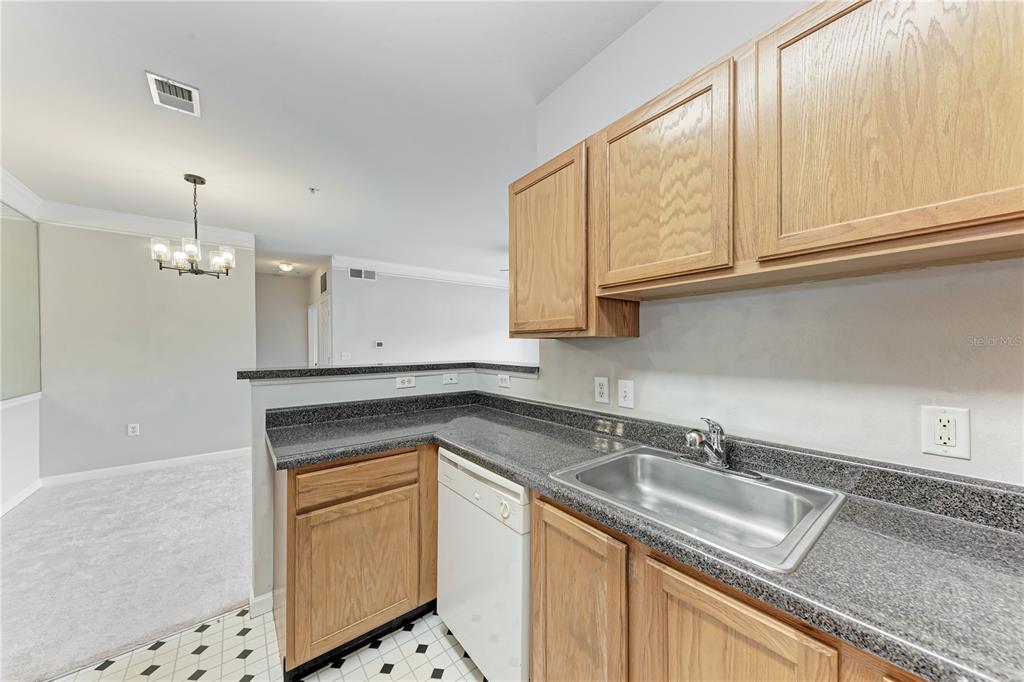 4802 51st Street West, Unit 1122 Bradenton, FL 34210 - Photo 17 of 37 a kitchen with granite countertop a sink a stove and cabinets