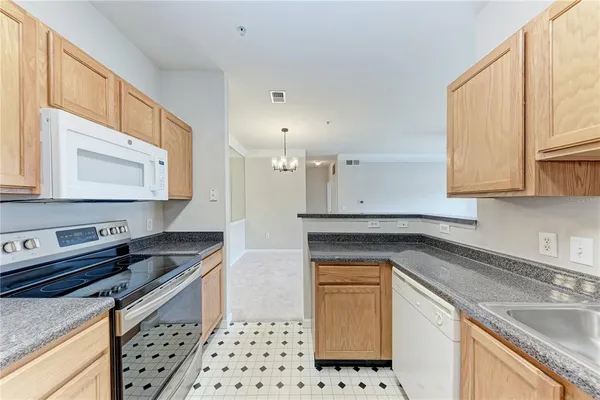 a kitchen with granite countertop a sink a stove and cabinets