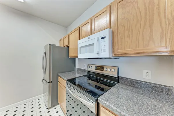 a kitchen with stainless steel appliances granite countertop a refrigerator and a stove