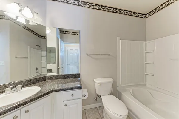 a bathroom with a granite countertop sink toilet mirror and shower